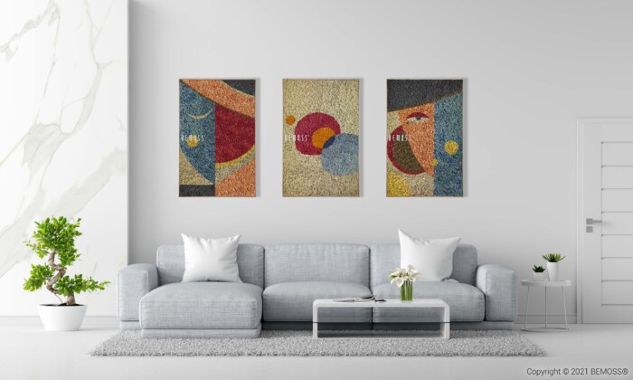 Een moderne woonkamer met een lichtgrijze bank versierd met witte kussens, geplaatst voor een witte muur. Boven de bank hangen drie abstracte kunstwerken en een abstracte Agallas. De kamer heeft aan de linkerkant een marmeren accentmuur, een potplant en een salontafel met bloemen.