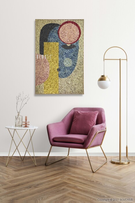 Een moderne woonkamerhoek met een roze fluwelen stoel met gouden poten, een witte bijzettafel versierd met decorartikelen en een gouden vloerlamp met een witte bolvormige kap. Aan de muur boven de stoel hangt een kleurrijk abstract kunstwerk, geaccentueerd door een abstracte Toril met weelderige groene texturen.
