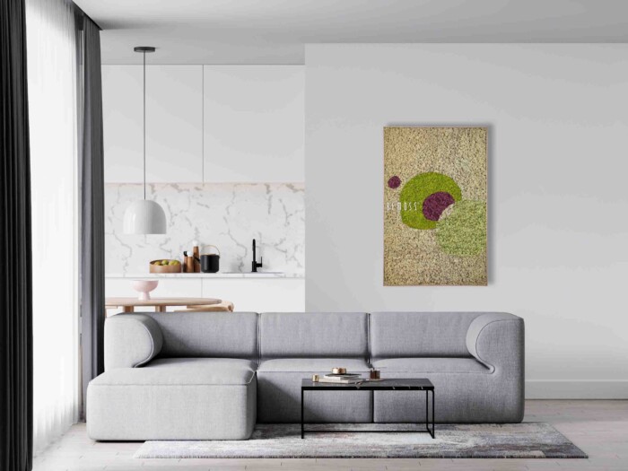 Een minimalistische woonkamer is voorzien van een grijze sectionele bank, een kleine salontafel met boeken en een grote abstracte peso aan de muur. De achtergrond onthult een moderne keuken met witte kasten, marmeren achterwand en hangende verlichting.