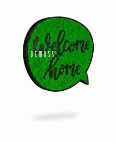 Op een groen tekstballonvormig bord met een gestructureerd oppervlak staat de tekst "Welcome Home" in cursieve letters. Het woord "Mosschilderij Acacia (114x188cm)" is elegant aan de linkerkant van het bord geplaatst. Het bord werpt een subtiele schaduw op een witte achtergrond, die doet denken aan een levendige moswand-esthetiek.