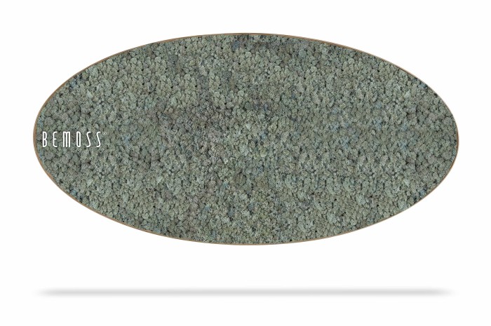 Een ovaalvormig, gestructureerd mosgroen vloerkleed met een dicht, bijna kiezelachtig oppervlak. Het woord 