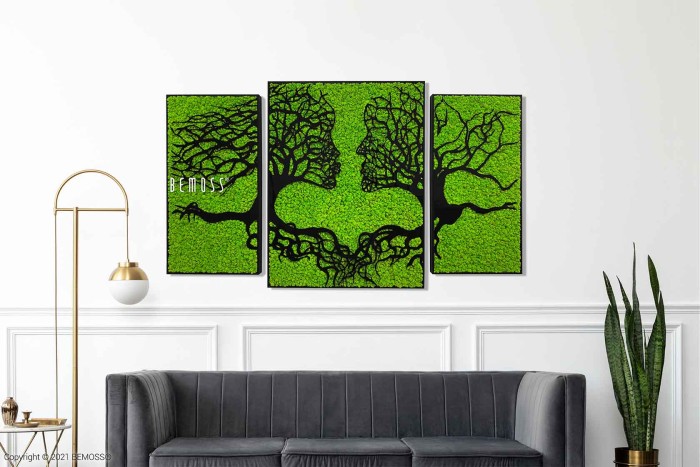 Een moderne woonkamer is voorzien van een grijze bank, een hoge vloerlamp met een gouden standaard en een slangenplant in pot. Aan de muur boven de bank tonen drie aangrenzende kunstwerken van Mosschilderij Acacia (114x188cm) ingewikkelde ontwerpen van boomachtige vormen.