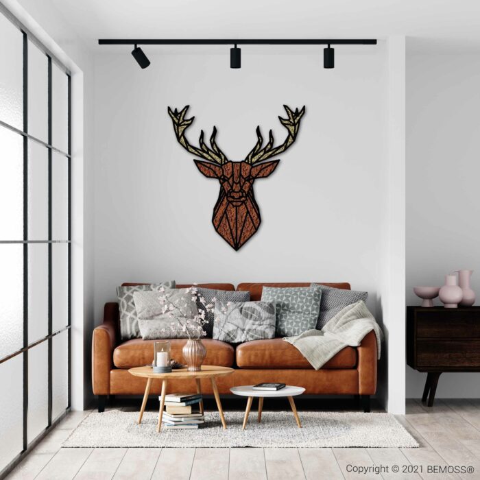 Een moderne woonkamer met een bruinleren bank, versierd met kussens met verschillende patronen en een deken. Boven de bank is een geometrische wanddecoratie met hertenkoppen gemonteerd, samen met een levendige BEMOSS moswand. Ervoor staat een ronde salontafel met decoratieve items en grote ramen laten natuurlijk licht binnen.