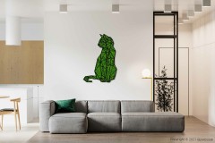 Een minimalistische woonkamer met een lichtgrijze zitbank met een groen kussen, een modern geometrisch kattenkunstwerk aan de muur en een verlichte vloerlamp naast de bank. De achtergrond omvat een eethoek en een keuken met houten kasten, versterkt door een BEMOSS-mosschilderij die textuur en groen toevoegt.