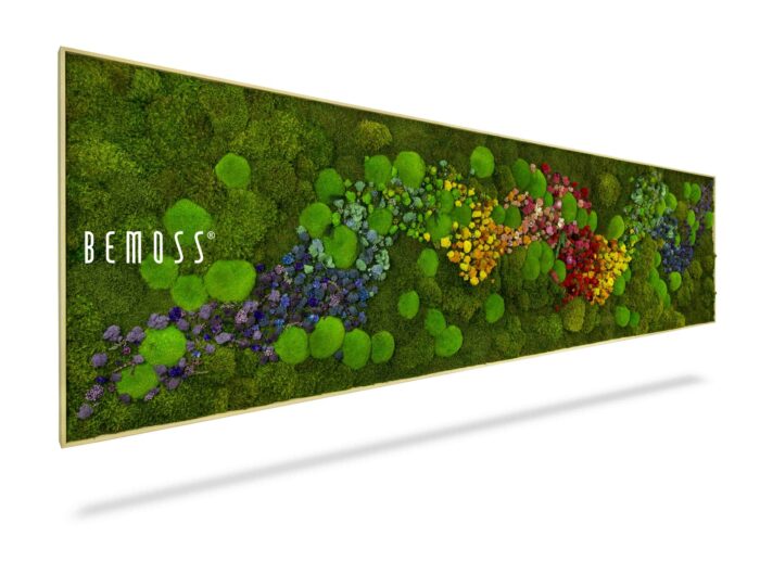 Een lange, rechthoekige BEMOSS-mosschilderij heeft levendig groen mos als achtergrond met een ingewikkeld, veelkleurig arrangement van geconserveerde bloemen en planten die een golfachtig patroon vormen in het midden. Het woord 