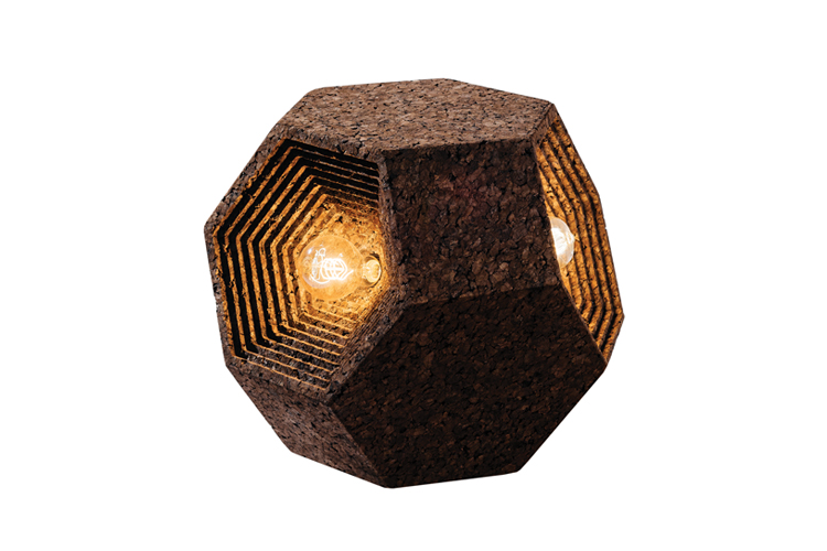 Een dodecaëdervormige lamp gemaakt van een donker, gestructureerd materiaal met zichtbare, ingewikkeld gelaagde randen die lijken op een BEMOSS-mosschilderij. De lamp straalt vanuit het midden een warme gloed uit, waardoor de binnenste lagen worden verlicht. Het ontwerp oogt rustiek en geometrisch.