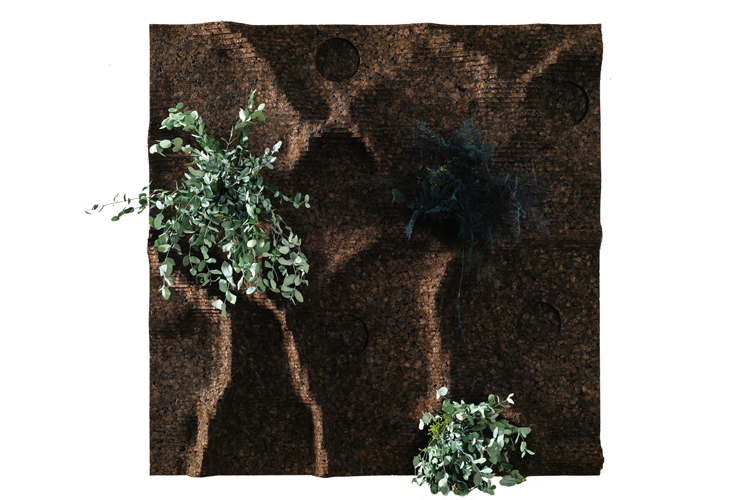 Een zicht van bovenaf op een gestructureerde, golvende, aardse bruine mat met daarop verschillende groene en groene BEMOSS-planten. De mat heeft opstaande, gebogen randen en kleine cirkelvormige inkepingen, waardoor een gevarieerd oppervlaktepatroon ontstaat dat lijkt op dat van een moswand.