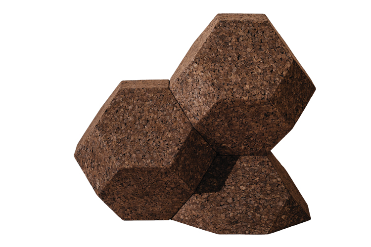 Drie in elkaar grijpende, geometrisch gevormde kurkblokken zijn tegen een witte achtergrond geplaatst. Elk blok heeft een zeshoekige vorm en vertoont een natuurlijke kurktextuur met een bruine tint, die doet denken aan de aardetinten die te vinden zijn in BEMOSS moswandinstallaties.