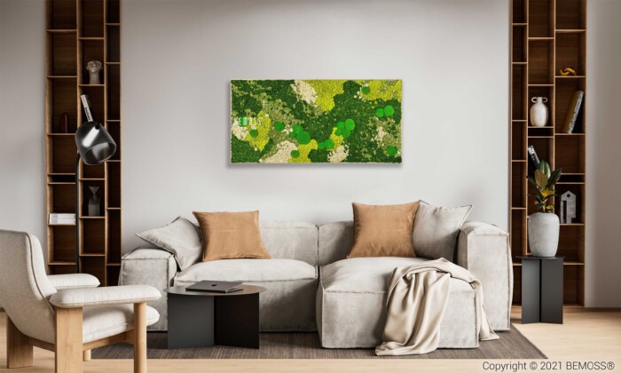 Een moderne woonkamer met een lichtgrijze zitbank versierd met lichtbruine en grijze kussens. Aan een beige muur boven de bank hangt een groen abstract schilderij, dat lijkt op een Mosschilderij BEMOSS® ORTHO SPRING. De kamer is voorzien van houten planken aan weerszijden, een zwarte vloerlamp en een zwarte salontafel.