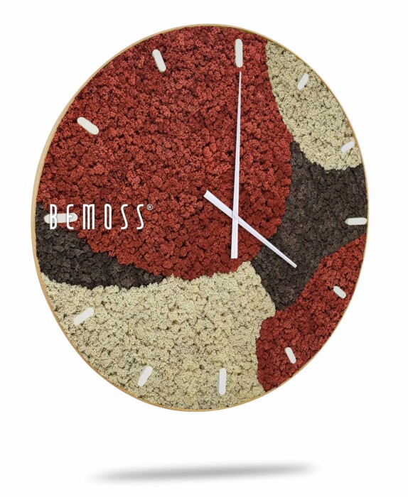 Een grote ronde wandklok met een uniek ontwerp met gestructureerde delen in rood, zwart en beige, die lijken op een mozaïek of abstracte kunst. De klok heeft minimalistische witte uren- en minutenwijzers zonder cijfers. De merknaam 