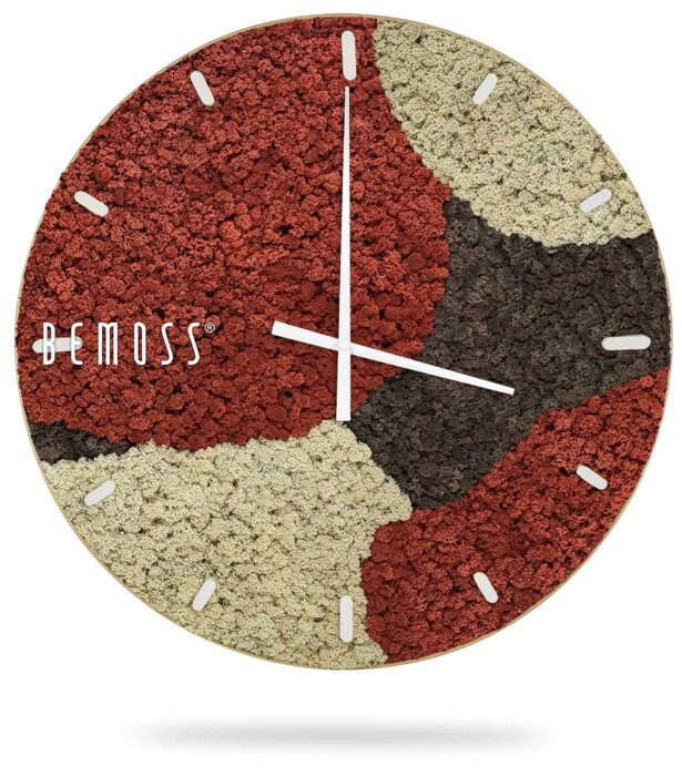 Een ronde wandklok met een mozaïekontwerp in rode, crème en donkerbruine tinten. De klok heeft dunne witte uren- en minutenwijzers en kleine rechthoekige markeringen voor de uren. De merknaam 