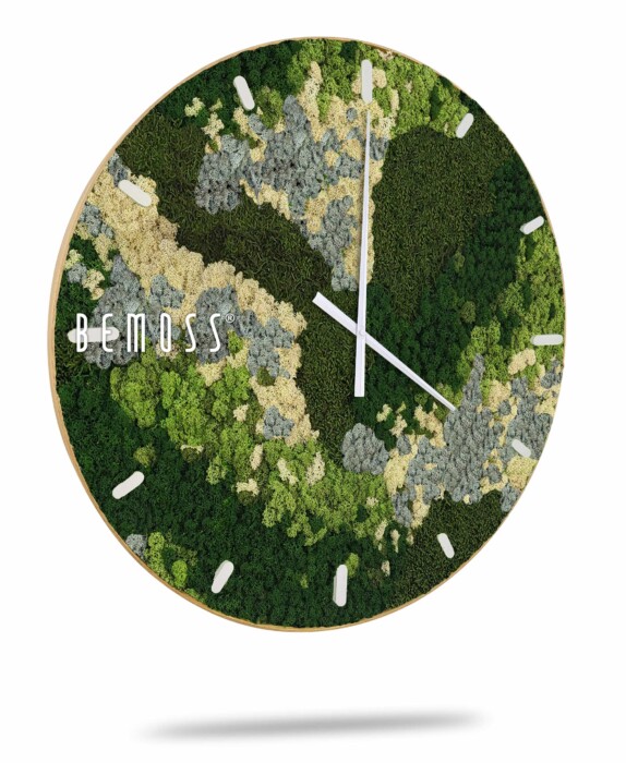 Een ronde wandklok met een uniek ontwerp waarin groene, lichtgele, grijze en witte mossen in een verlooppatroon zijn verwerkt. De klok heeft eenvoudige witte uurmarkeringen en wijzers. De merknaam 