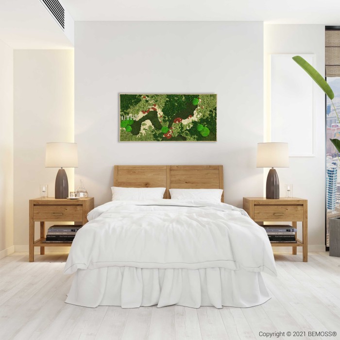 Een moderne slaapkamer met een houten bedframe en wit beddengoed. Twee houten nachtkastjes met lampen flankeren het bed. Boven het bed hangt een Mosschilderij BEMOSS® ORTHO MANGO in groene en rode tinten. De kamer heeft lichtgekleurde muren en vloer, met in de rechterhoek een plant zichtbaar.