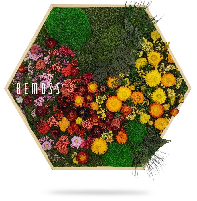 Zeshoekig houten frame gevuld met een scala aan kleurrijke, levendig bewaarde bloemen en groen. Het arrangement bevat verschillende tinten gele, rode, roze en oranje bloemen, samen met verschillende texturen van groen blad en BEMOSS-mos, waardoor een levendig, natuurlijk kunstwerk ontstaat.