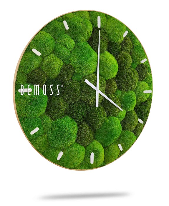 Een ronde wandklok met een groene, met mos bedekte wijzerplaat en witte wijzers en uurmarkeringen. De merknaam 