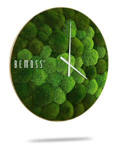 Een Mos klok BOLMOSS Minerva met wijzerplaat met een ronde wijzerplaat bedekt met weelderige groene mosachtige textuur. De uren- en minutenwijzers zijn wit en minimalistisch en contrasteren met de levendige groene achtergrond. De merknaam "BEMOSS" wordt in witte tekst weergegeven aan de linkerkant van de wijzerplaat.