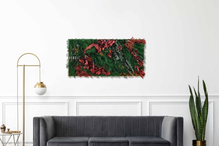 Een moderne woonkamer met een grijze bank, een hoge gouden vloerlamp met witte bolkap en een opvallende BEMOSS moschilderij als wandkunst in groen en rood. Als aanvulling op de ruimte staat een hoge slangenplant. De muren zijn wit met sierlijsten.