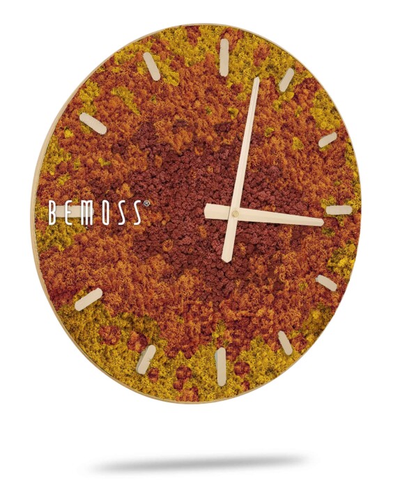 Een ronde wandklok met een kleurrijke Mos klok BEMOSS® SPLASH Sienna met wijzerplaatontwerp op de wijzerplaat, met tinten geel, oranje en rood. De klok heeft minimalistische houten uren- en minutenwijzers en twaalf beige houten uurmarkeringen. Aan de linkerkant is de merknaam 