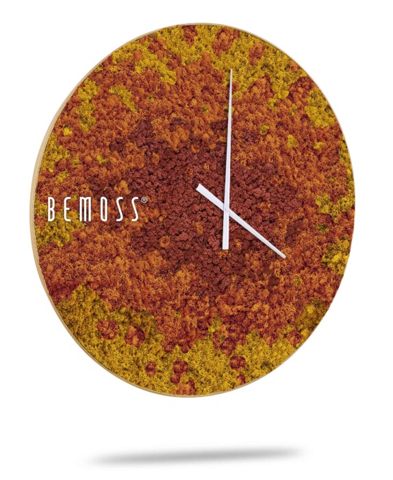 Een ronde wandklok met een bemoste textuur in rode en gele tinten. De klok heeft eenvoudige witte uren- en minutenwijzers zonder cijfers op de wijzerplaat. Aan de linkerkant is de merknaam 