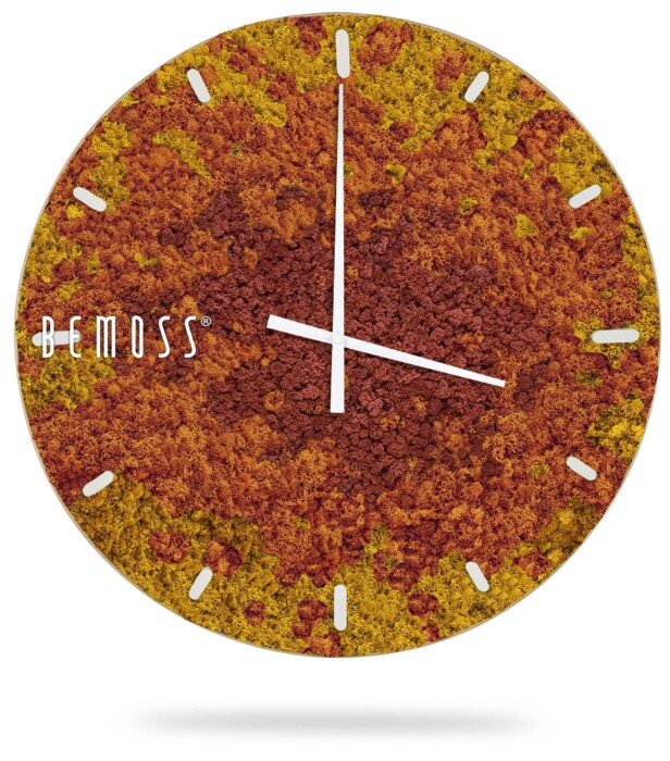 Een ronde wandklok met een uniek gestructureerd oppervlak dat lijkt op levendig, aards mos en aarde in de kleuren rood, oranje en geel. De klok heeft witte uren- en minutenwijzers, witte uurmarkeringen en de merknaam 