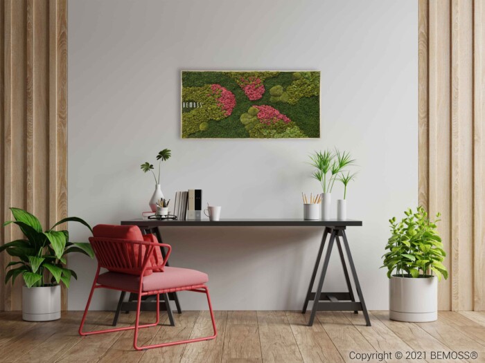 Bij een minimalistische kantoorinrichting hoort een zwart bureau met daarop diverse kantoorbenodigdheden en planten. Voor het bureau staat een rode stoel. Groen omringt het bureau met extra potplanten. Erboven hangt een wandgemonteerde Mosschilderij BEMOSS® ORTHO MEDIUM.