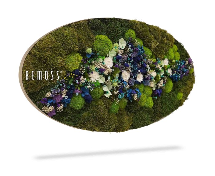 Een ovale verticale tuin met verschillende soorten mos en een mix van kunstbloemen in de kleuren groen, paars, blauw en wit. De merknaam 